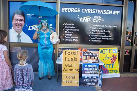 Photo: Mermaid Ocean Activist at a Climate Protest Against Fossil Fuel Donations & Subsidies at the Office of Far-Right Politician. Video: Displaced Mermaids Genetic Link To Bleached Reef Corals